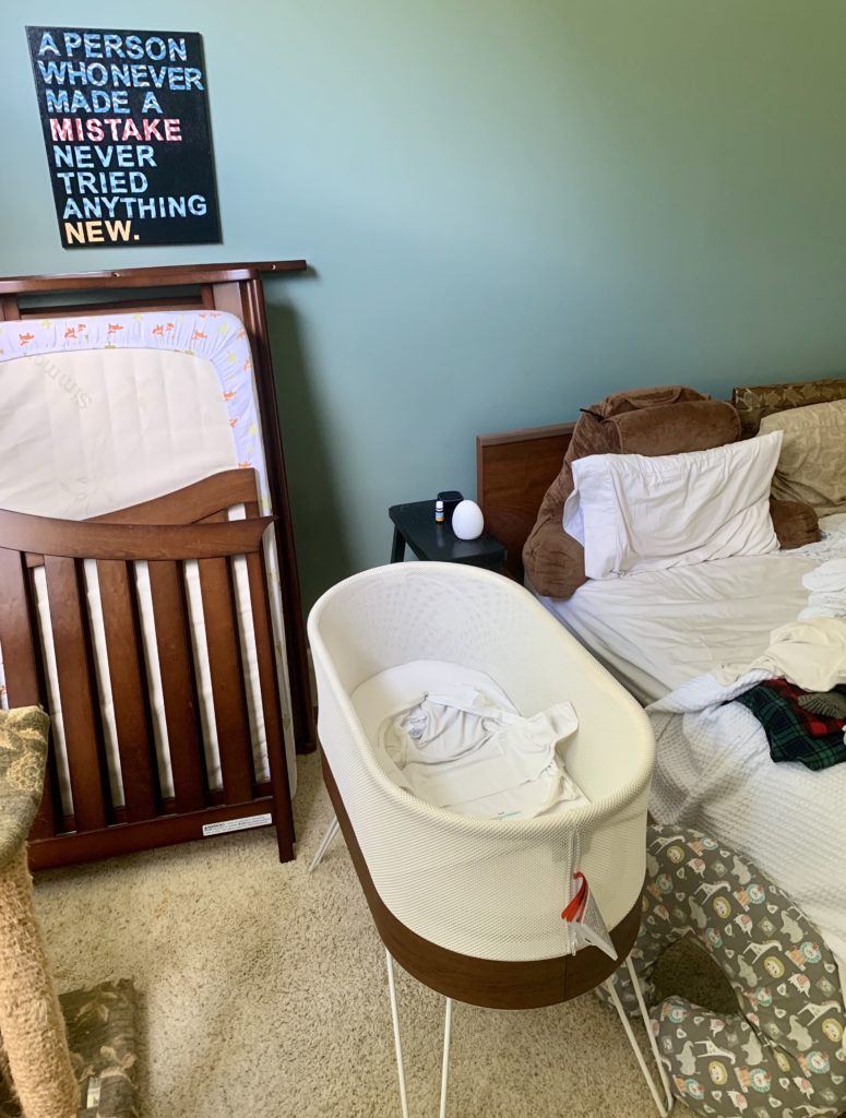 Picture of SNOO bassinet next to unmade bed
